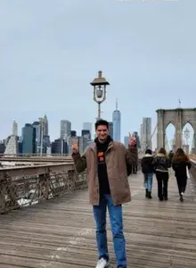 Diego on a bridge smiling holding up two peace signs