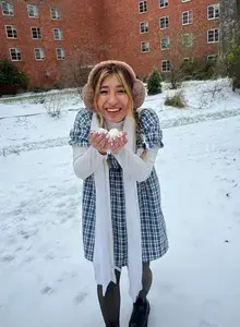 Jazmin smiling holding up two snowballs